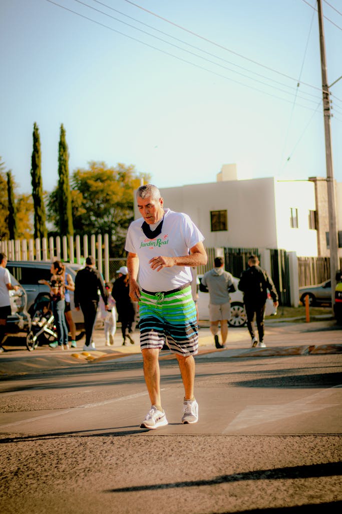 Senior adult jogging on a sunny street, showcasing active lifestyle and health.